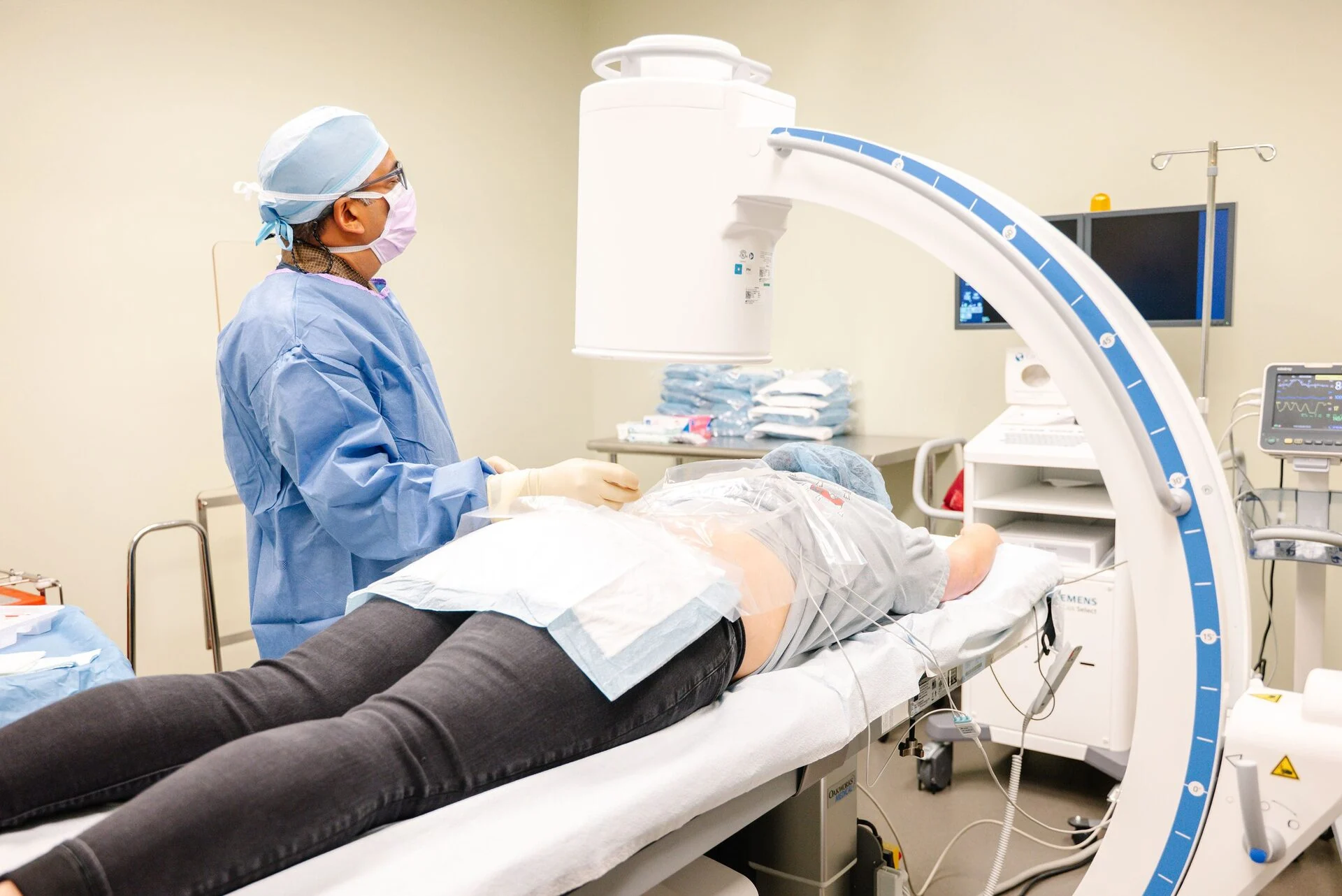 Provider performing an image-guided spine procedure with a C-arm fluoroscope